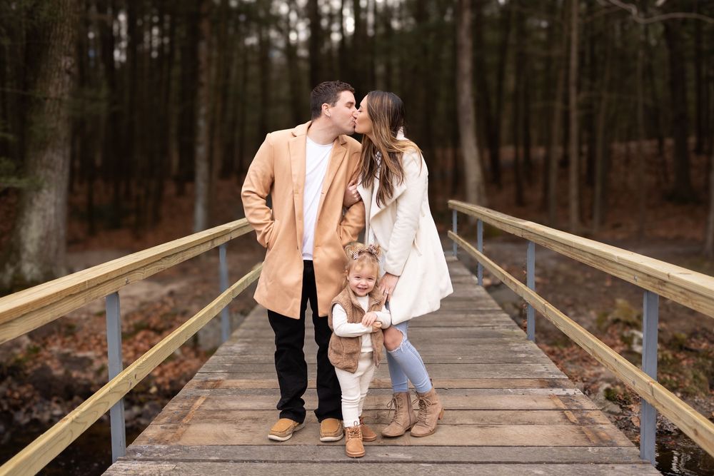Couple walking hand in hand on a wooden boardwalk through a pine forest. Fall Mini Session