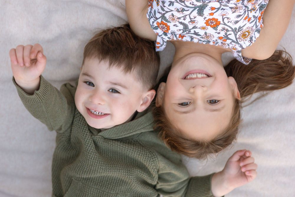A collage of candid family moments showing children and parents laying on a light colored floor together.