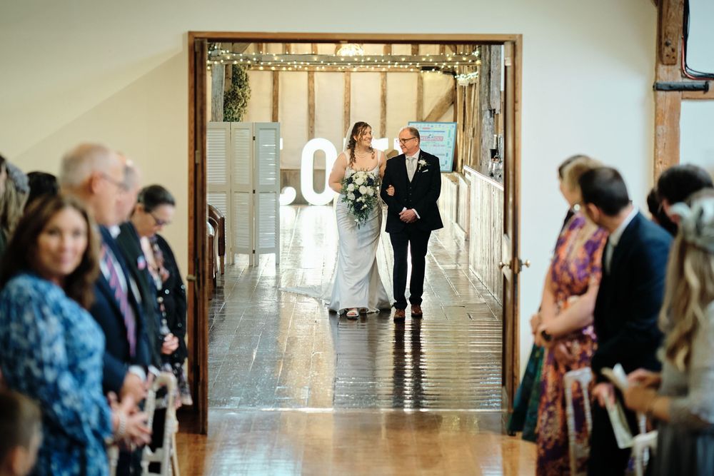 A sequence of wedding photos showing guests mingling and walking through an elegant hallway with glass walls.