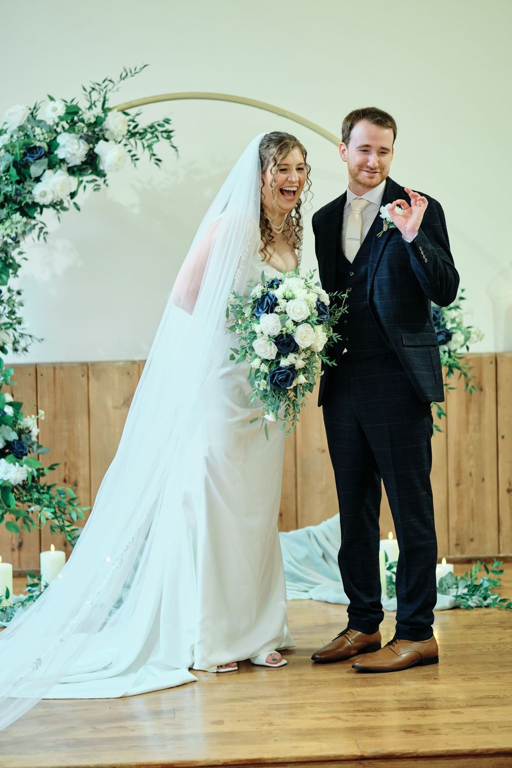 A couple in wedding attire shares a sweet moment together during their photo session in a rustic indoor venue.