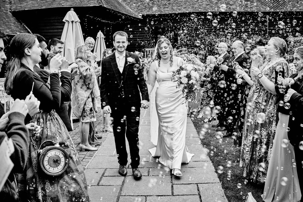 Wedding guests shower the happy couple with flower petals and confetti as they exit the ceremony.