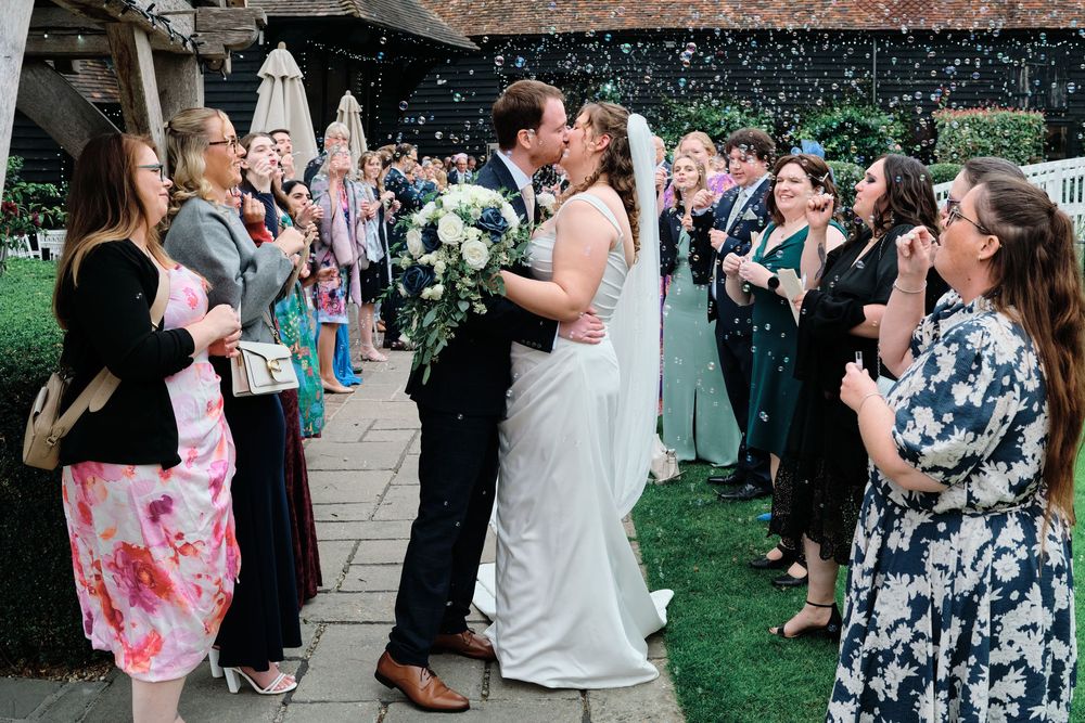 Wedding guests dance together on an outdoor patio during an evening reception celebration.