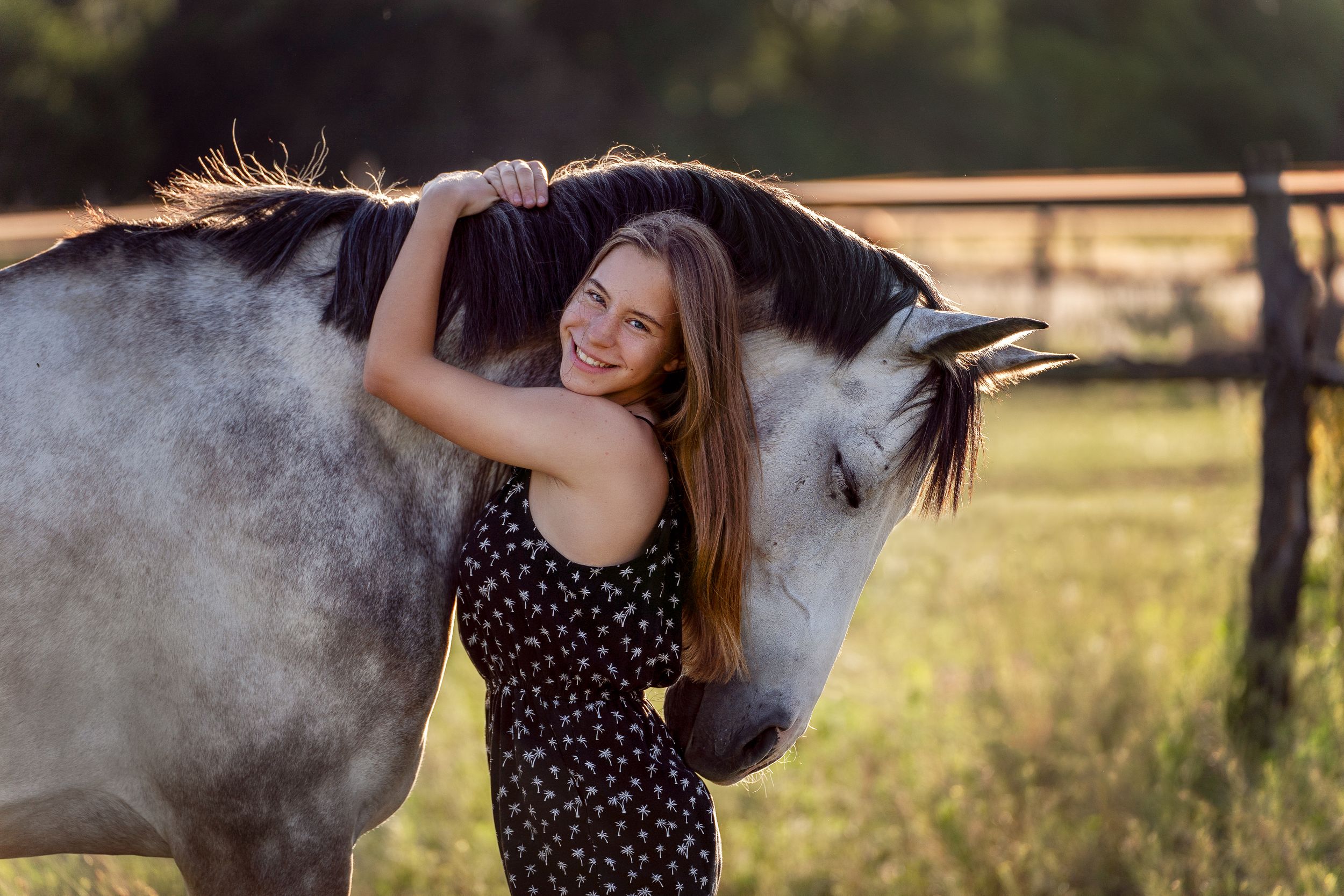 girl hugging her grey horse during golden hour in Sydney year 12 formal photoshoot with a horse in Dural