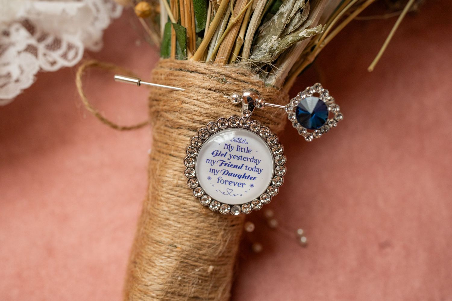 Rustic twine-wrapped glass jars adorned with vintage paper tags and crystal embellishments create elegant wedding decor.
