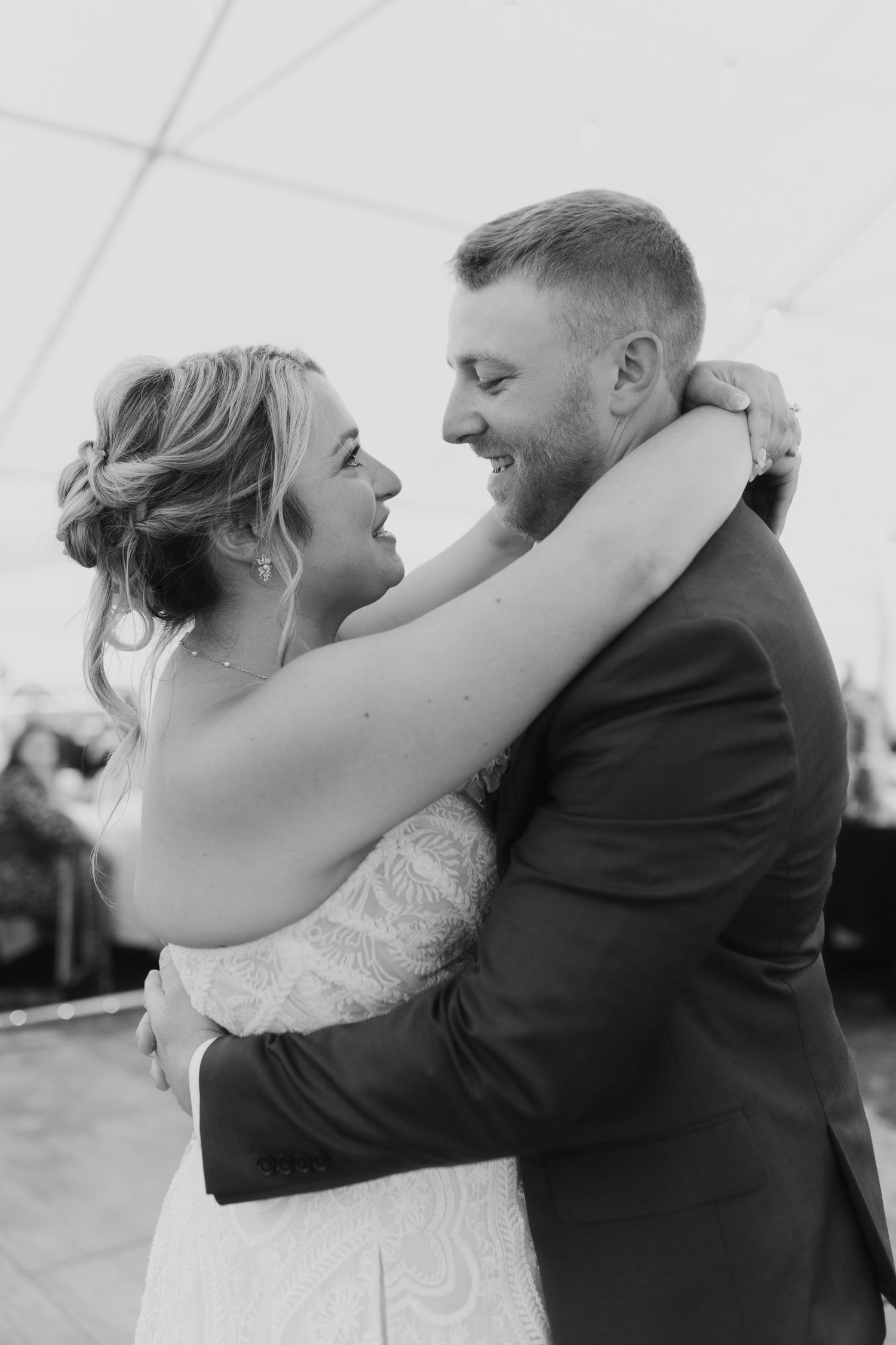 A series of black and white photos showing a couple dancing and embracing at their wedding reception.