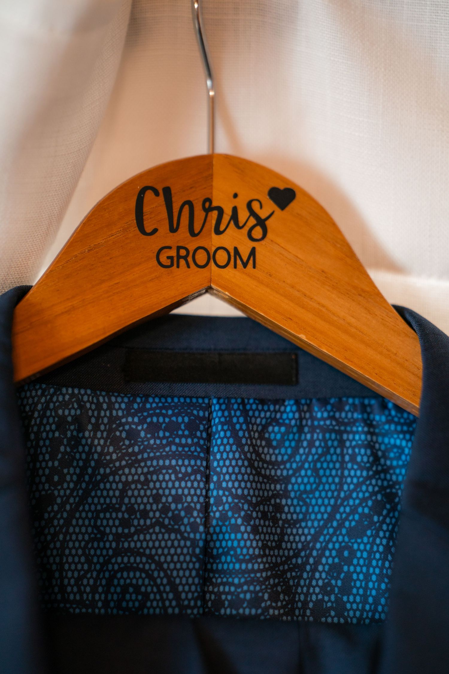 Wooden hangers with 'Groom' text displayed against a navy blue background.