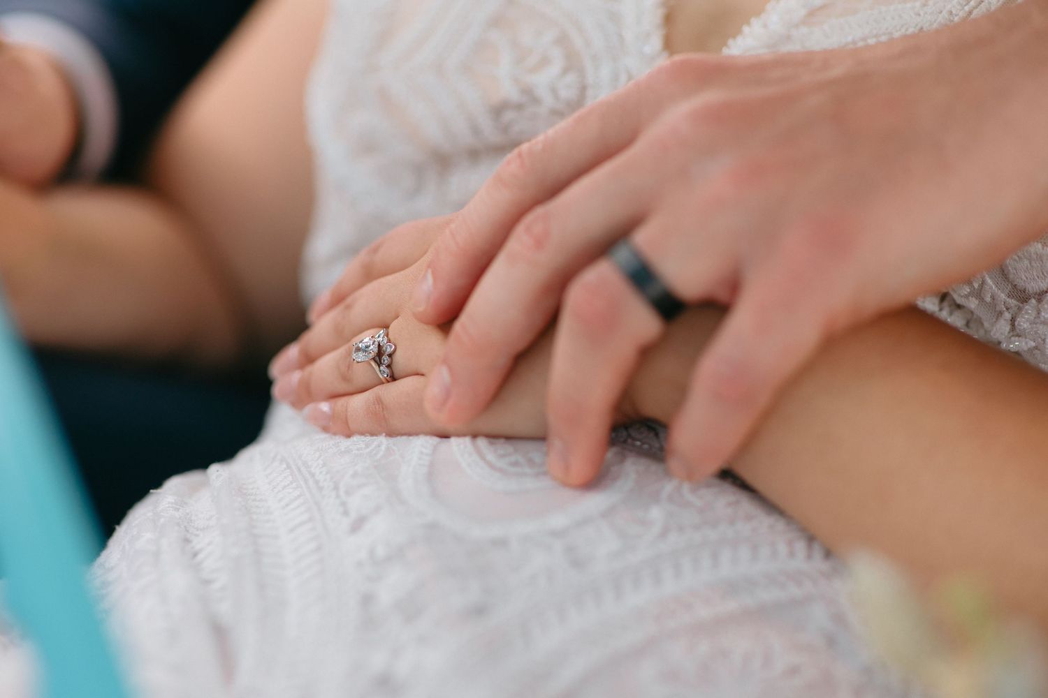 Close-up detail of delicate lace on a white wedding dress.
