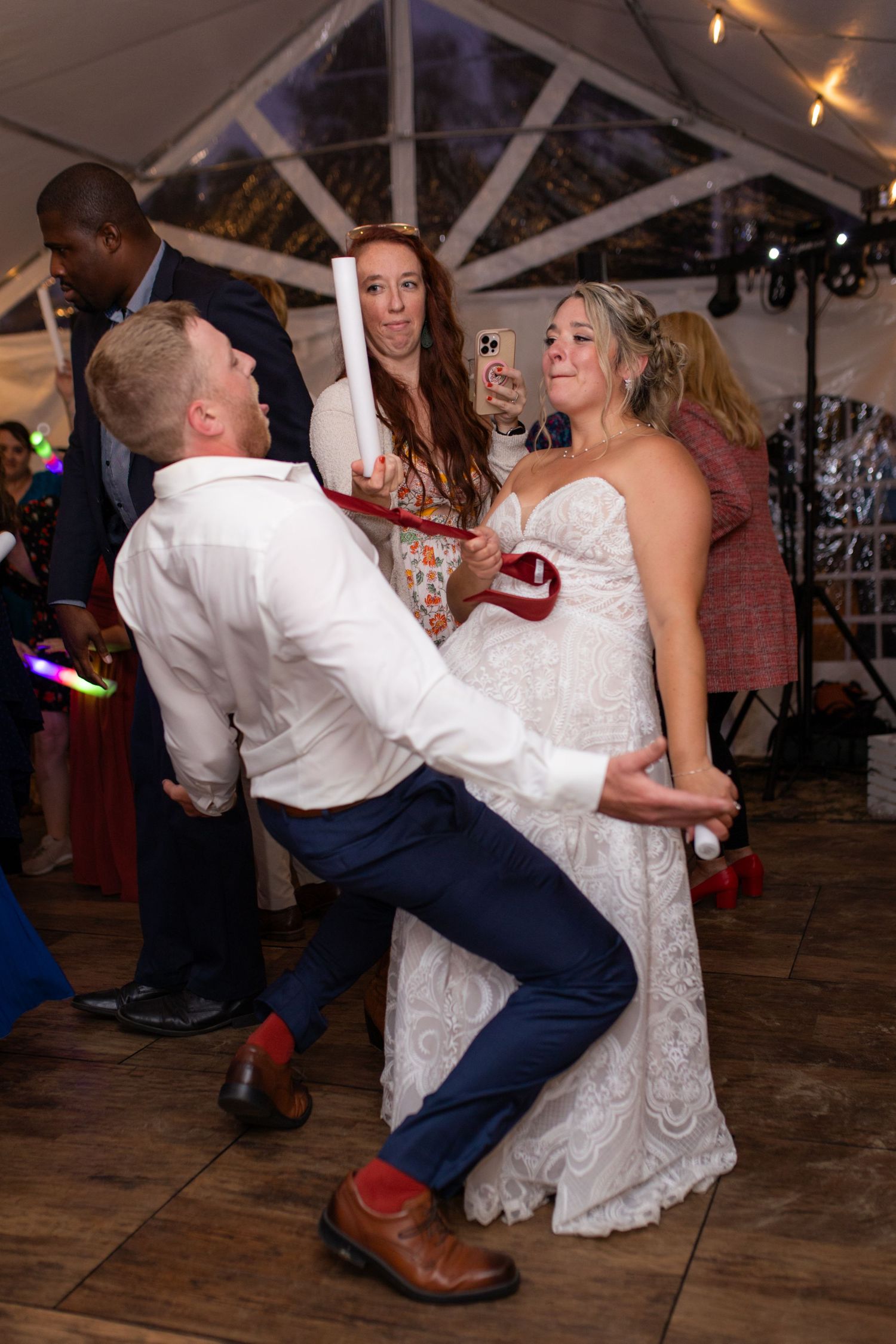 Sequence of dance floor photos showing guests performing energetic dance moves at a rustic wedding reception venue.