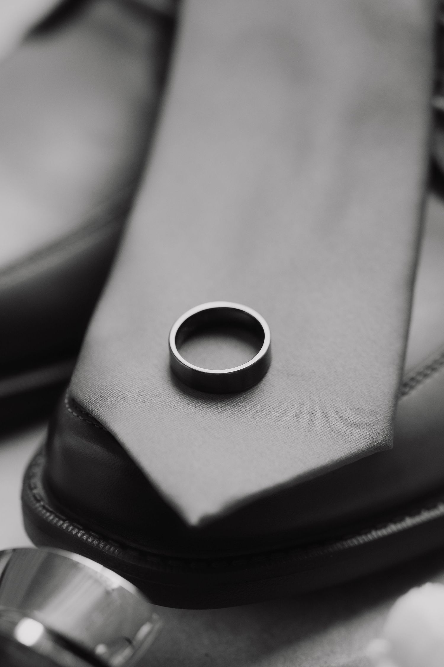 Close-up black and white detail shot of formal menswear accessories.