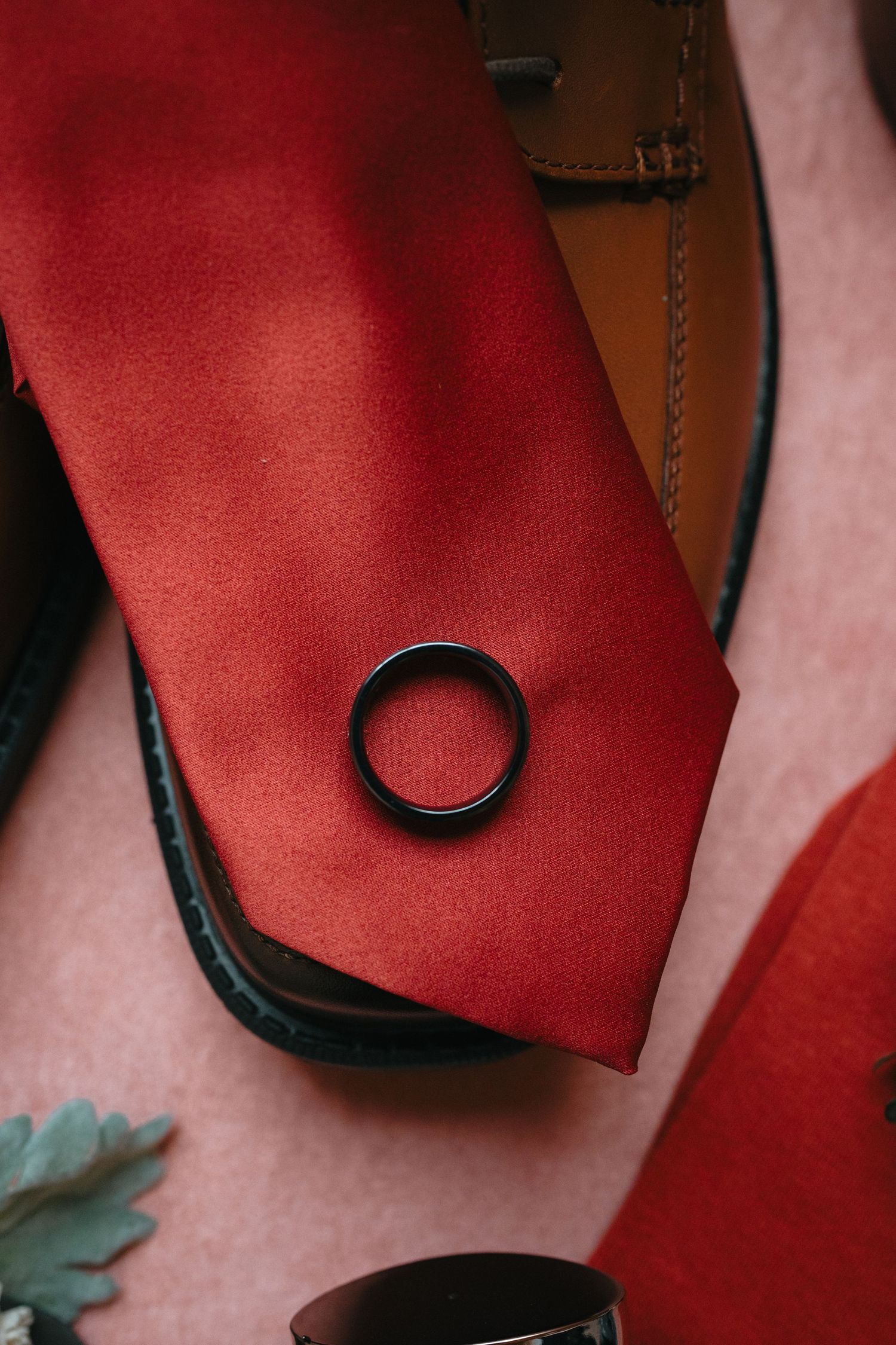 Close-up of red heels and formal shoes arranged in a row on a wooden floor.