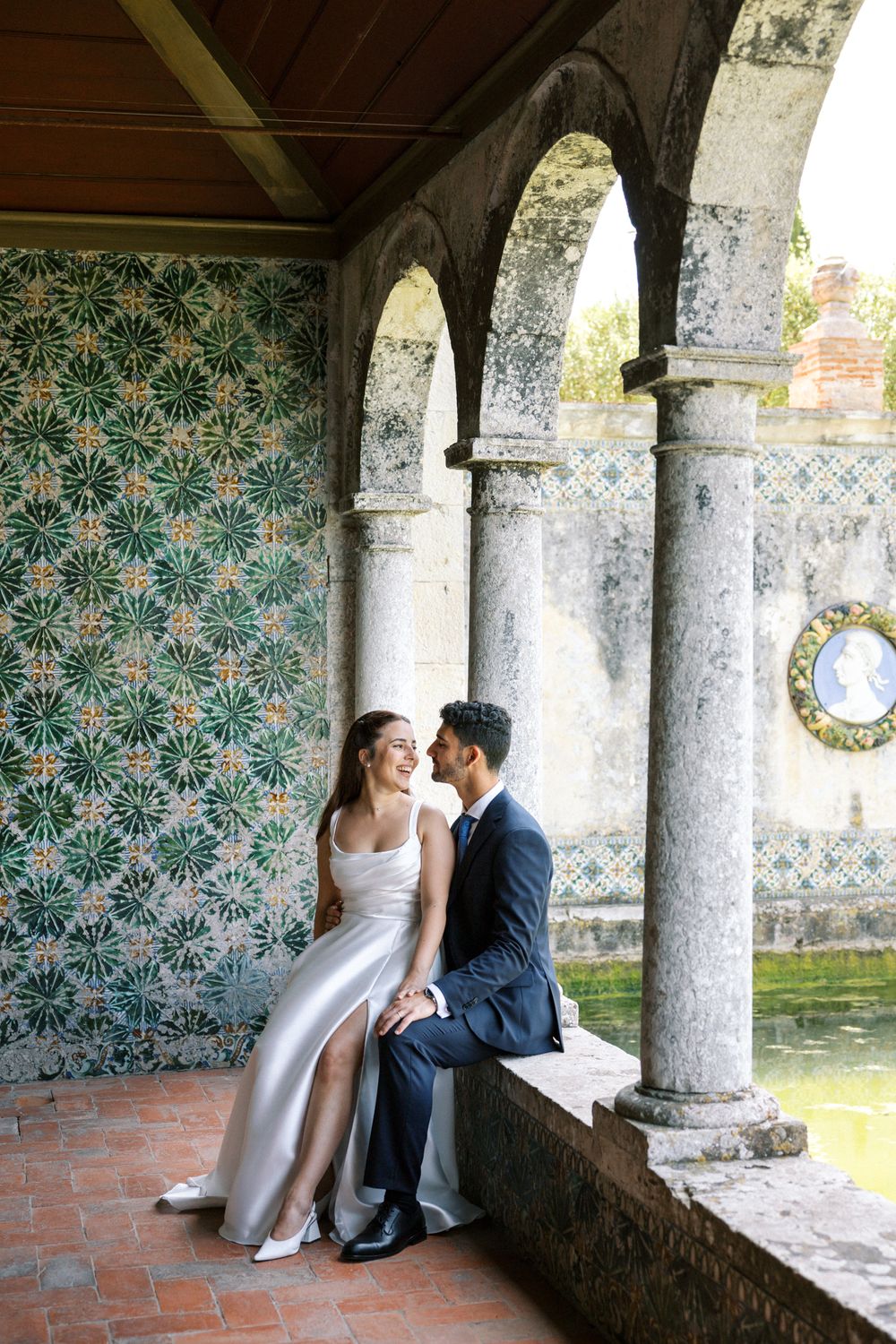 Bride and groom in front of historic azulejos at Palácio da Bacalhôa Portugal