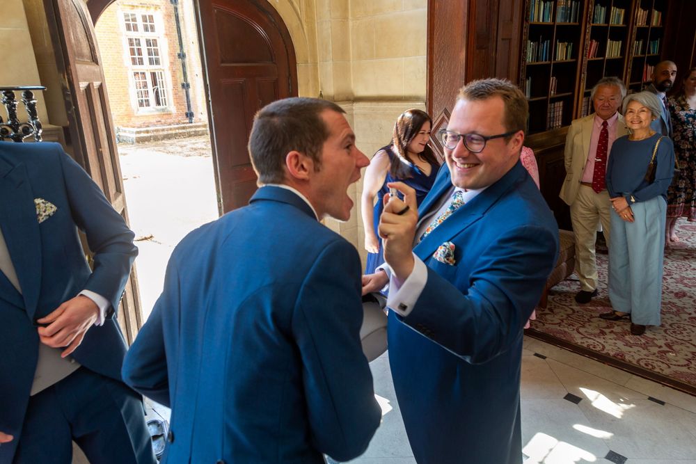 A sequence of candid moments showing people in blue suits embracing and celebrating at an indoor venue.