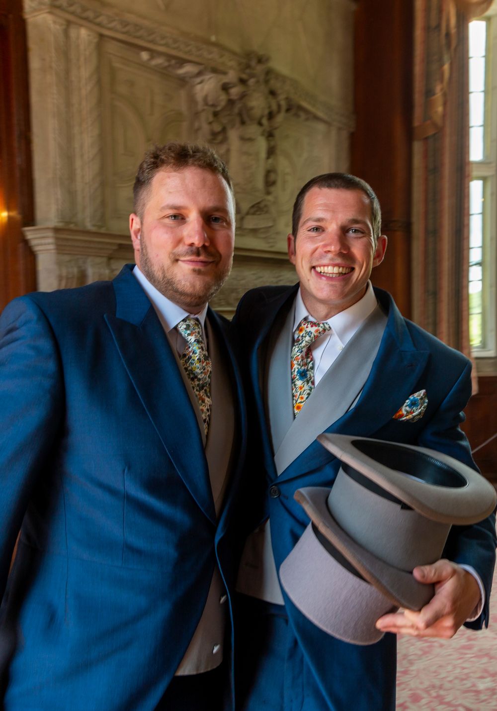 A series of four candid photos showing two people in blue suits sharing a lighthearted moment with grey cowboy hats.