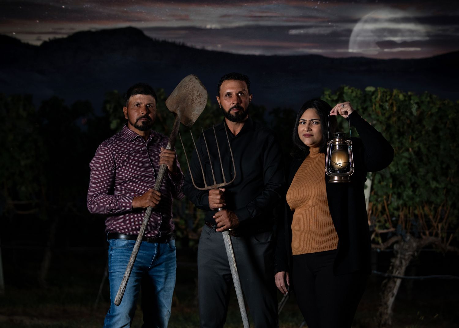 Three Moon Curser Winery owners holding lantern, shovel, and pitchfork under full moon - moody Okanagan band photo.