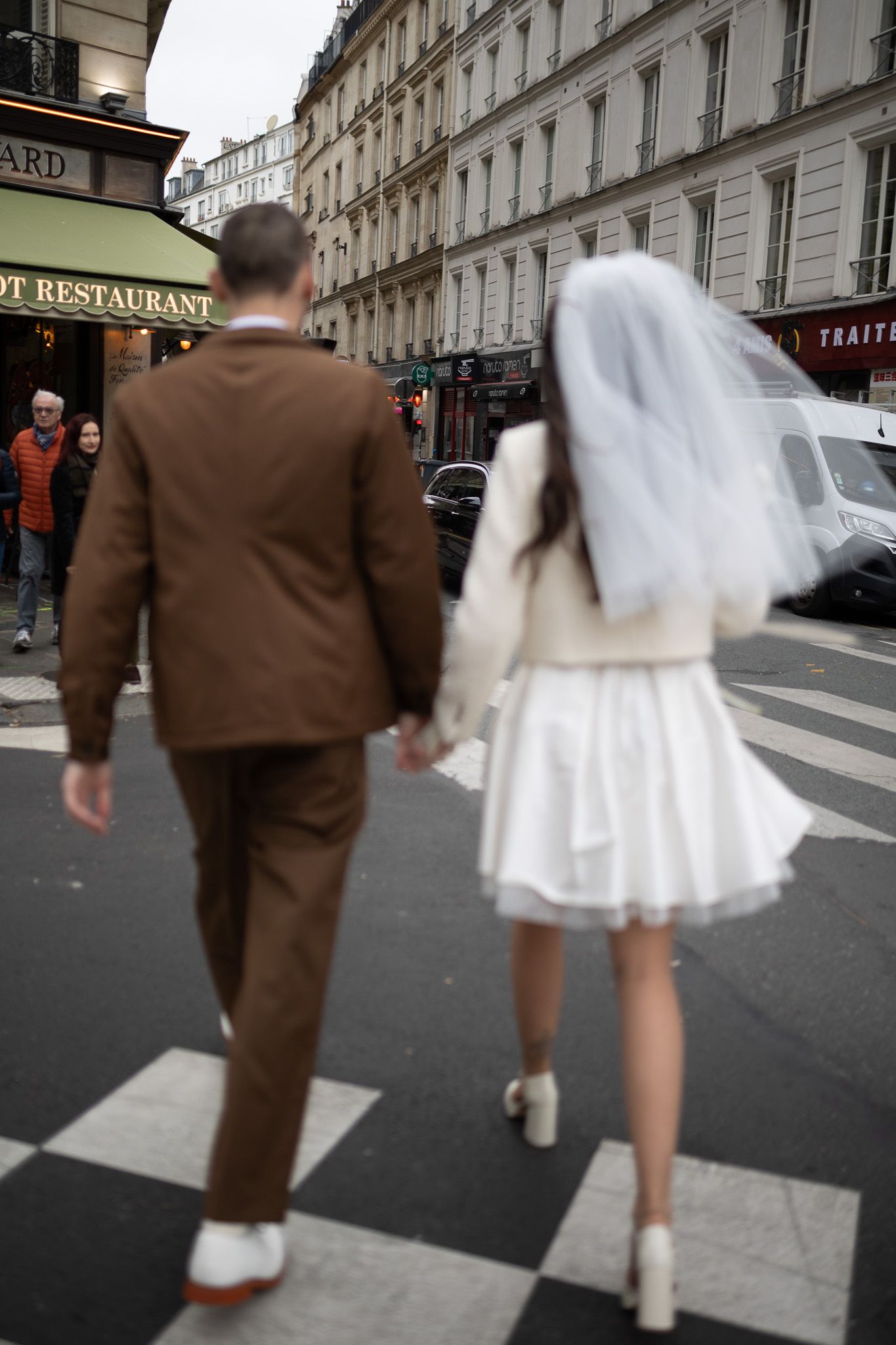 mariés qui traversent une rue dans paris