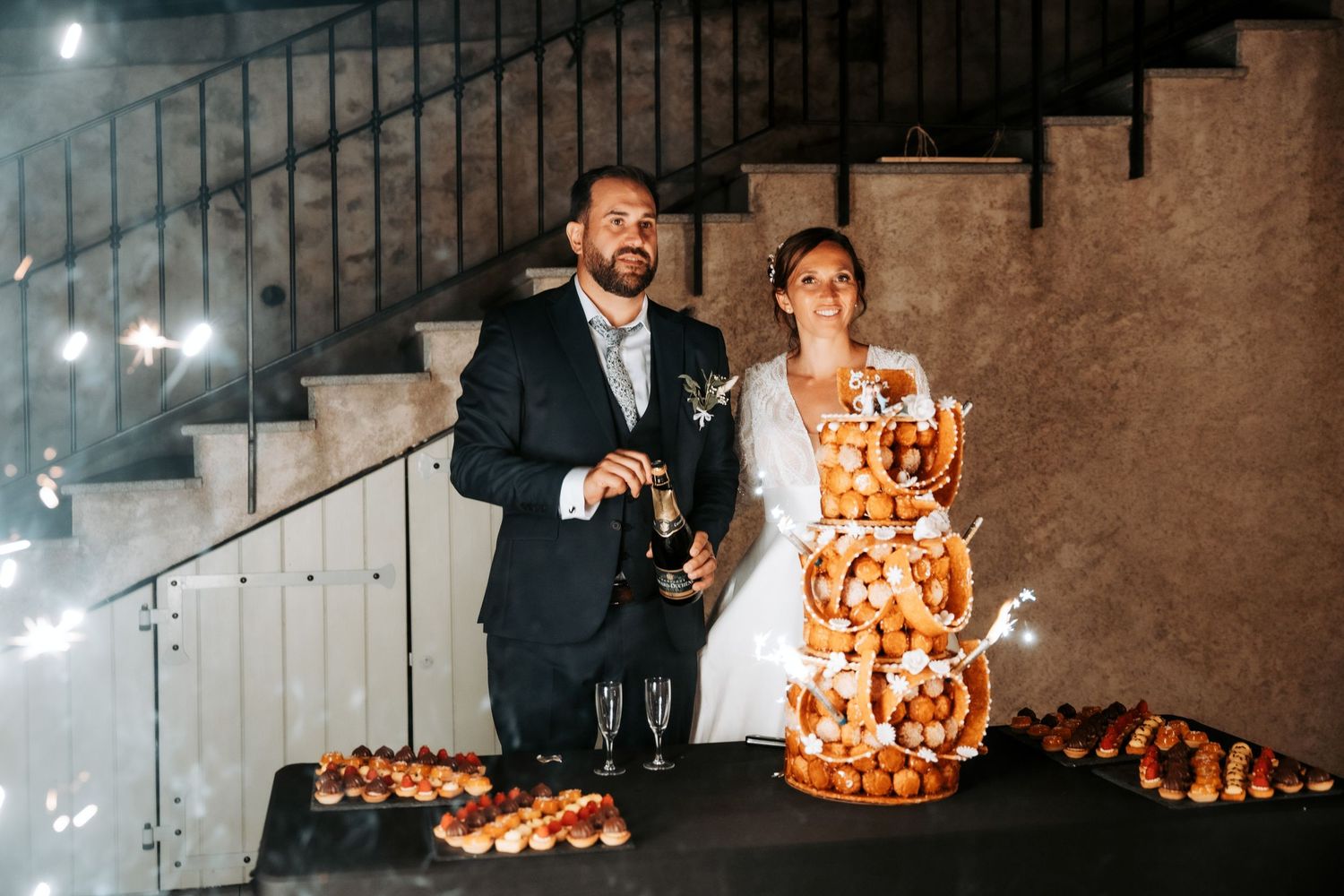 Wedding cake with sparklers creating a magical display during a celebration. Domaine la Plume photographe mariage