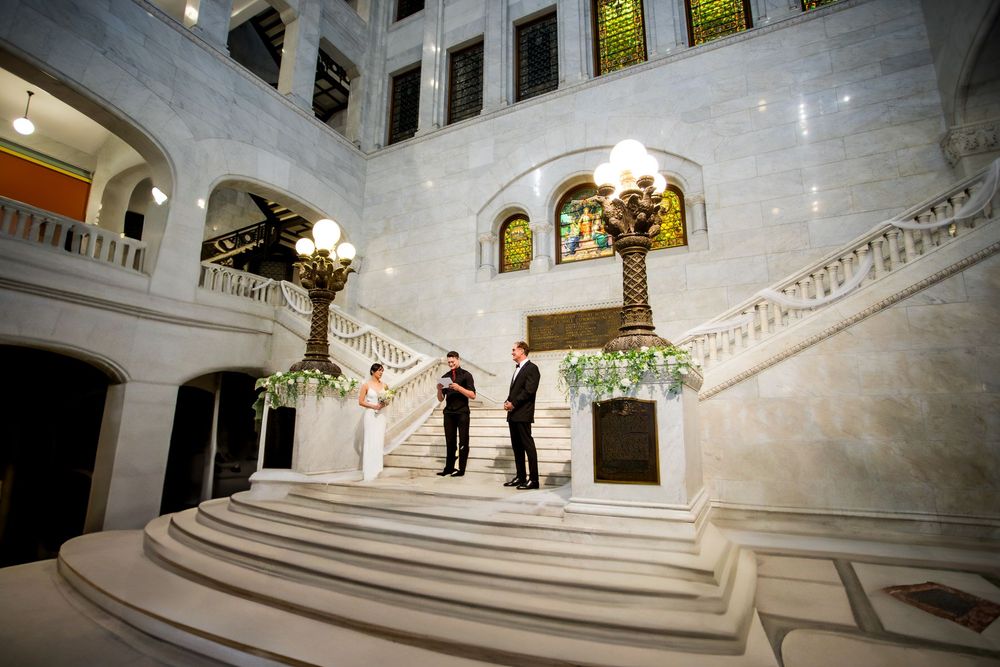Elegant white marble staircase with ornate railings and decorative details in a grand historic building interior.