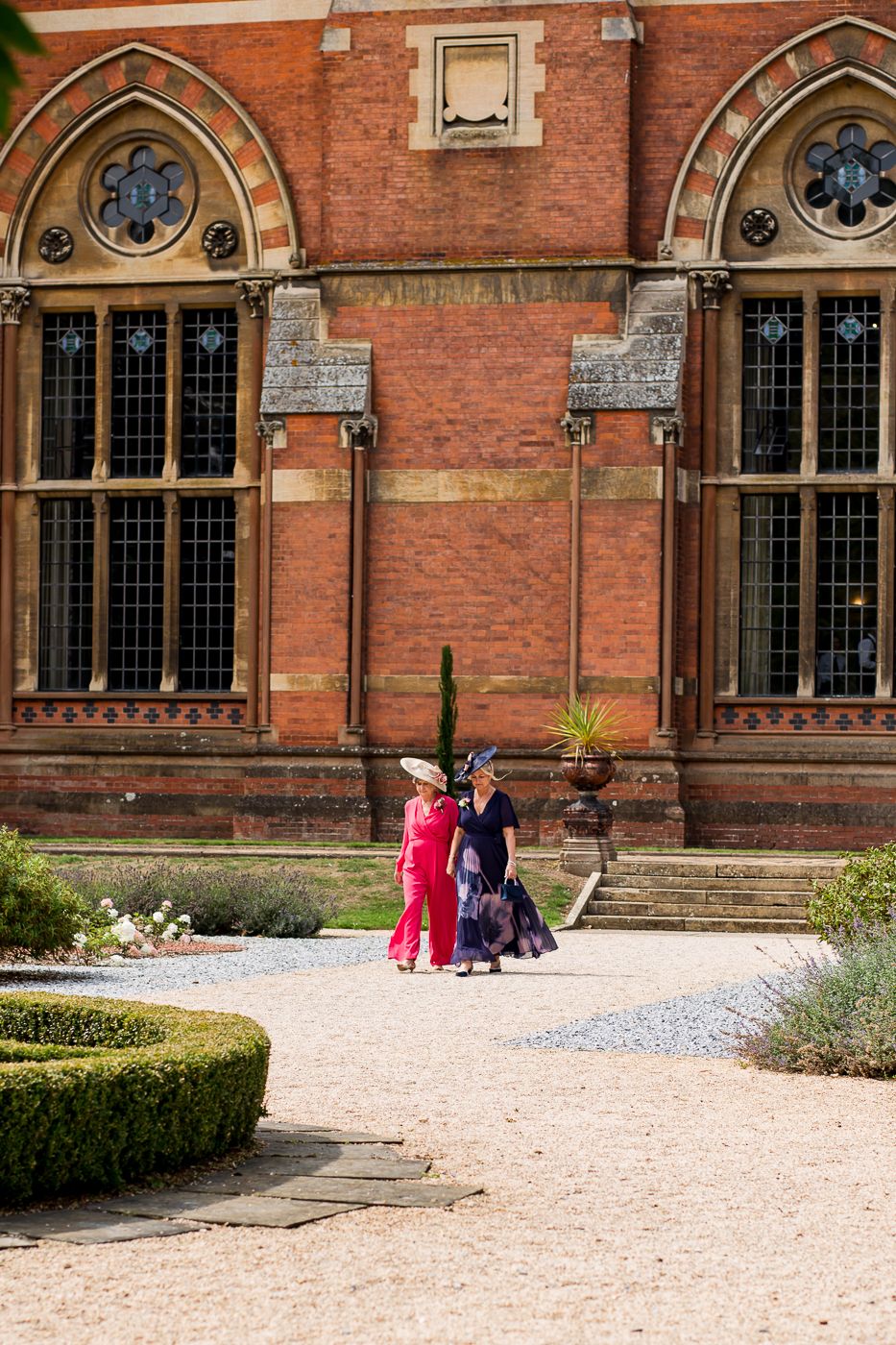 Gothic-style red brick building with arched windows serves as an elegant wedding venue.