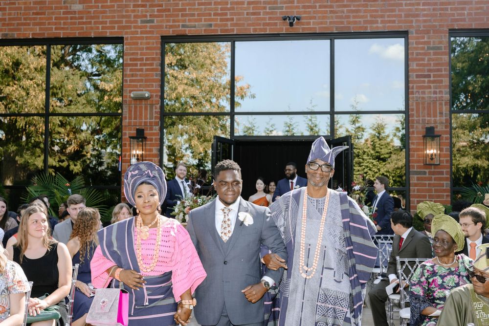 Guests mingle and socialize at an elegant outdoor wedding reception venue with brick architecture.