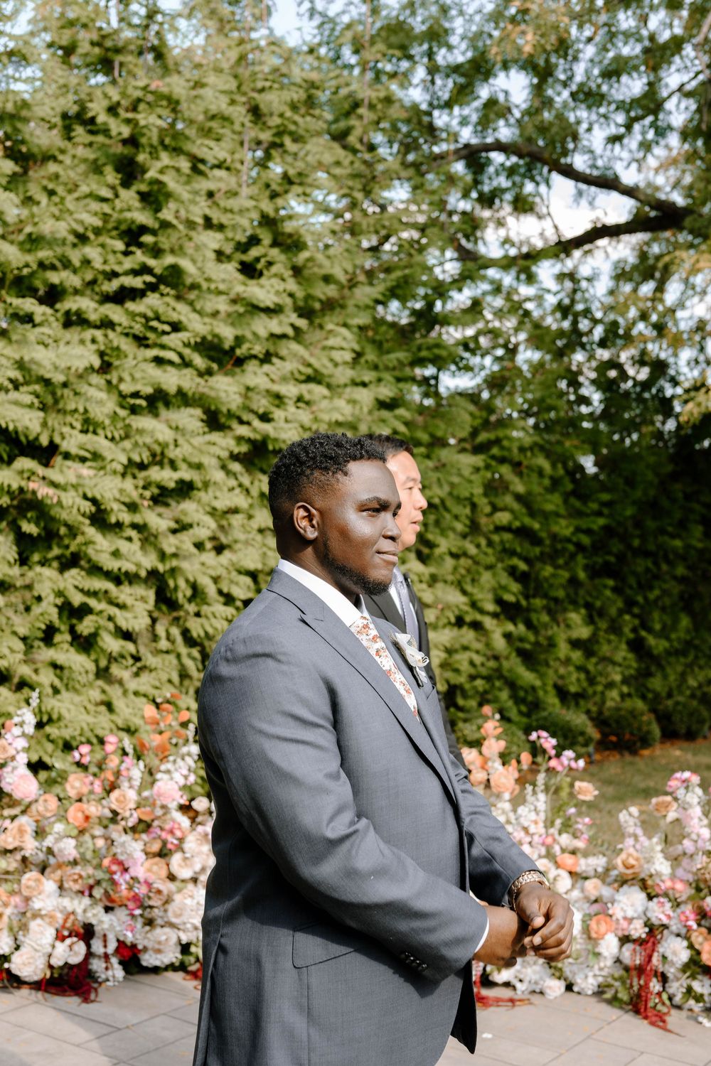 Emotional reactions captured during an outdoor wedding ceremony with beautiful floral arrangements and greenery in the background.