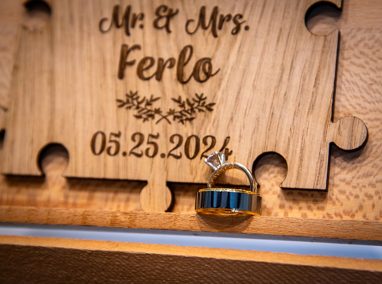 A wooden puzzle piece wedding sign with "Mr. & Mrs. Ferlo" and a blue wedding ring displayed in front. (Fairport New York)