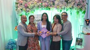 Panoramic view of a festive event space decorated with floral arrangements and mint green drapery.