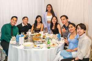 Friends gathered around dining tables at a celebration event.
