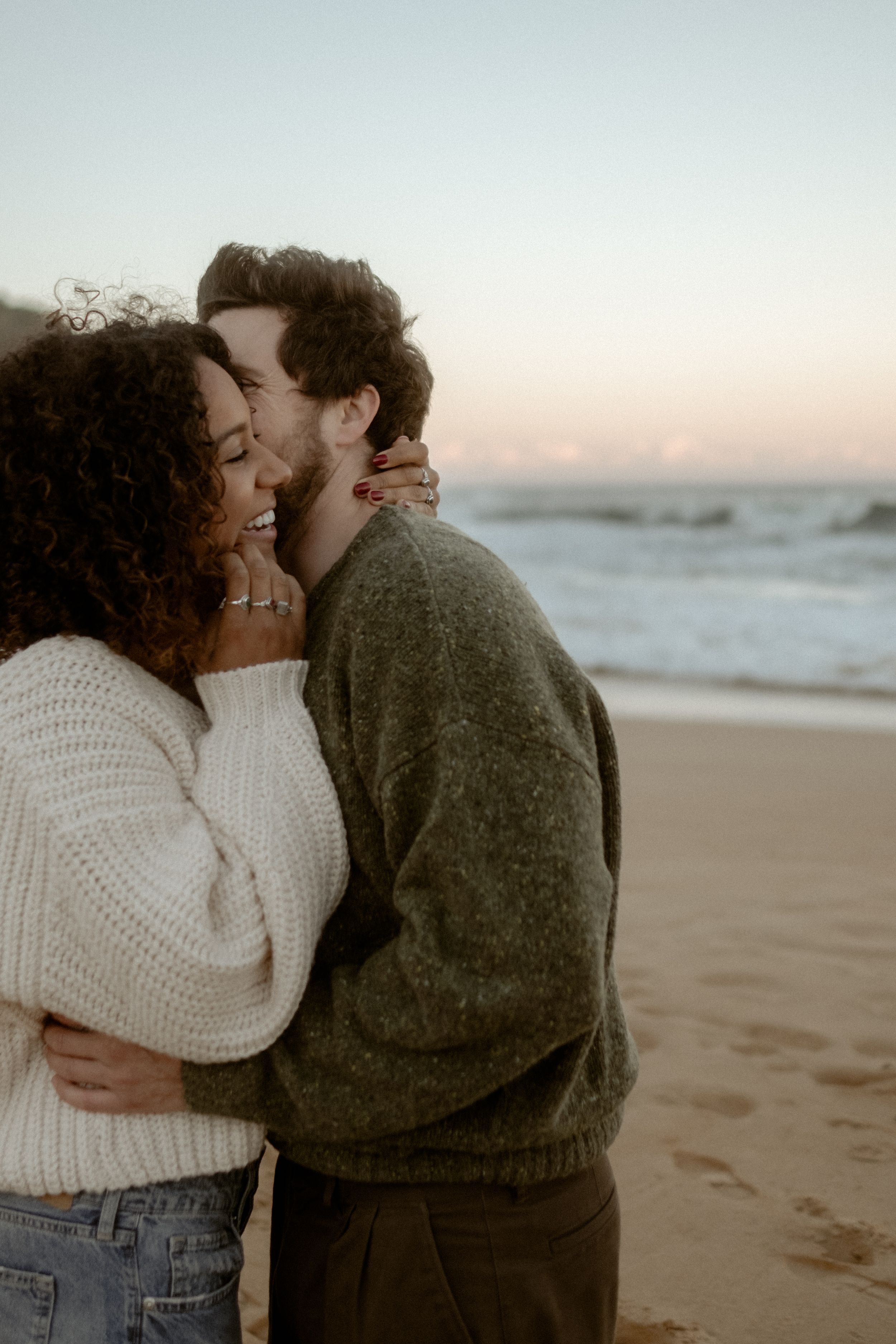 Smiling couple whispering something into each other's ears.