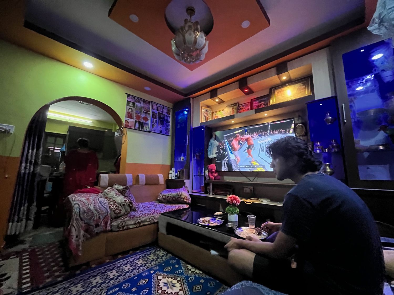 Dimly lit entertainment room with colorful ambient lighting and screens.