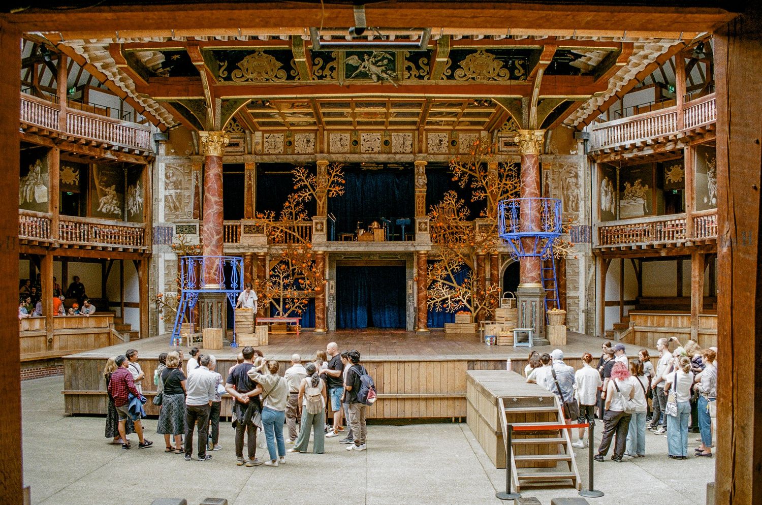 Interior view of Shakespeare's Globe Theatre in London showing the wooden stage and audience gallery spaces.