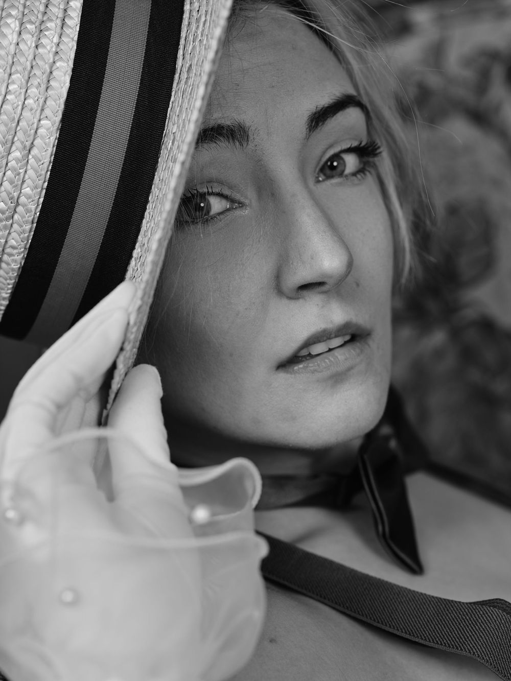 Dramatic black and white portrait of someone looking away with a soft light on their face.