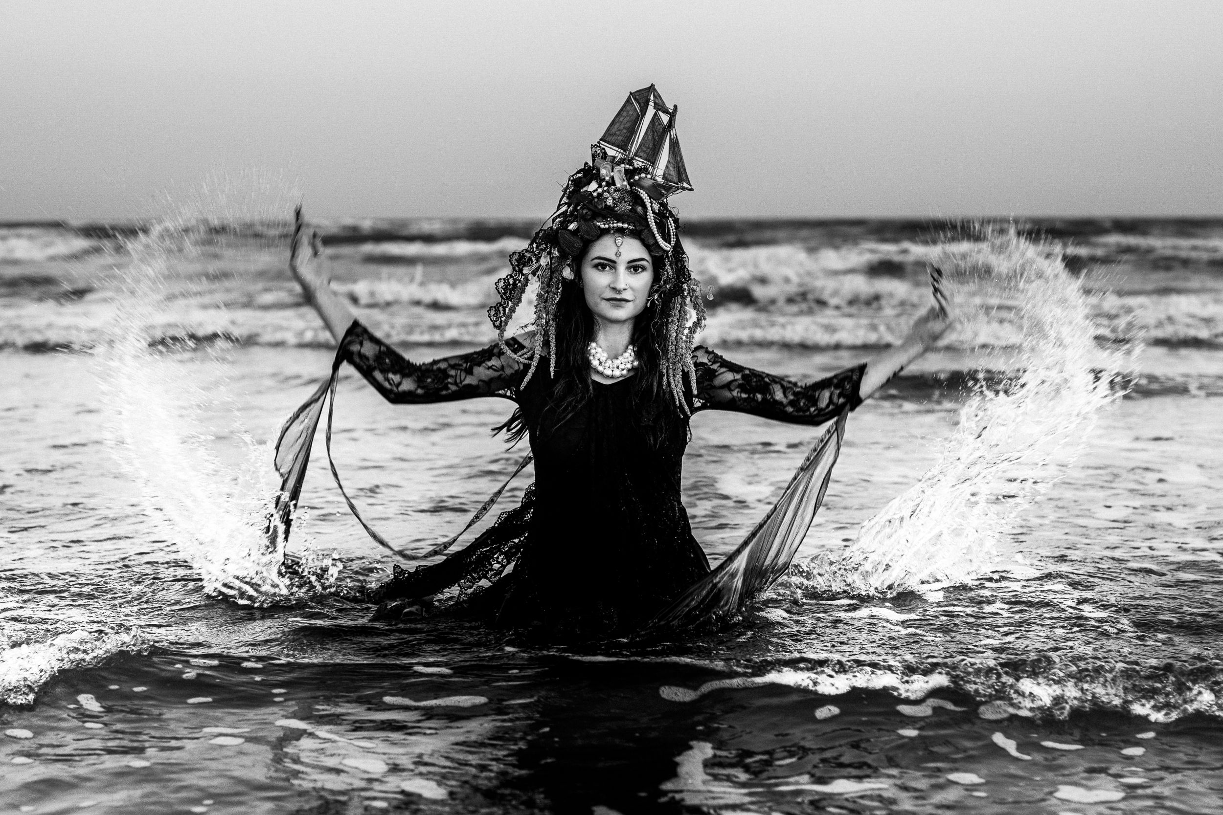 Black and white, Elegant ocean-themed portrait at golden hour, handmade ship crown, black gown, fantasy beach shoot in Essex County.