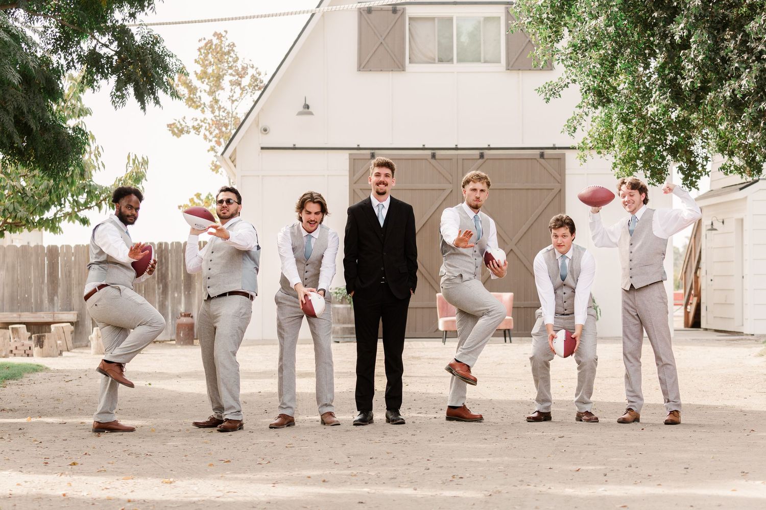 Groomsmen in gray suits performing fun poses for wedding party photos.