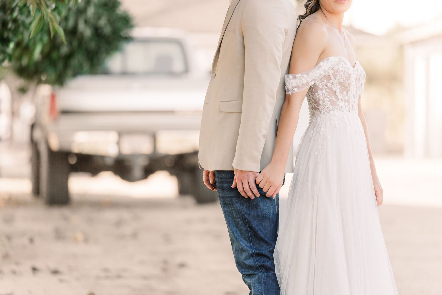 Elegant outdoor wedding portrait session with flowing white dress against natural backdrop.