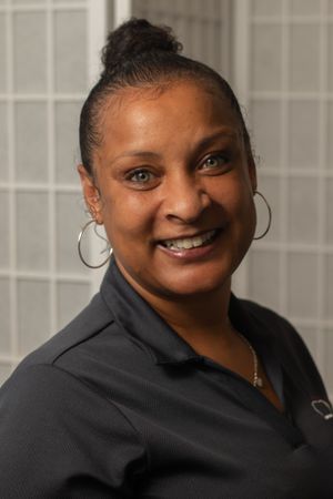 Professional business headshot featuring neat bun hairstyle and hoop earrings.
