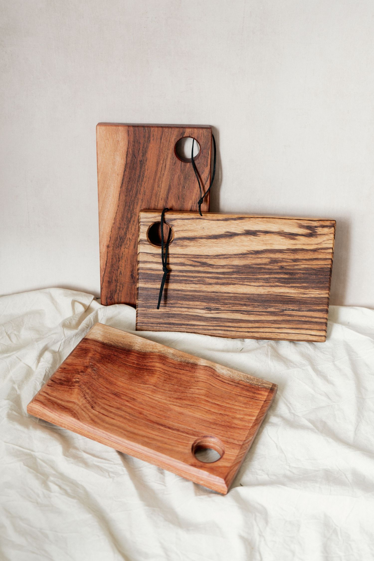 a studio pack photo of three wooden boards in a neutral background with textile addition