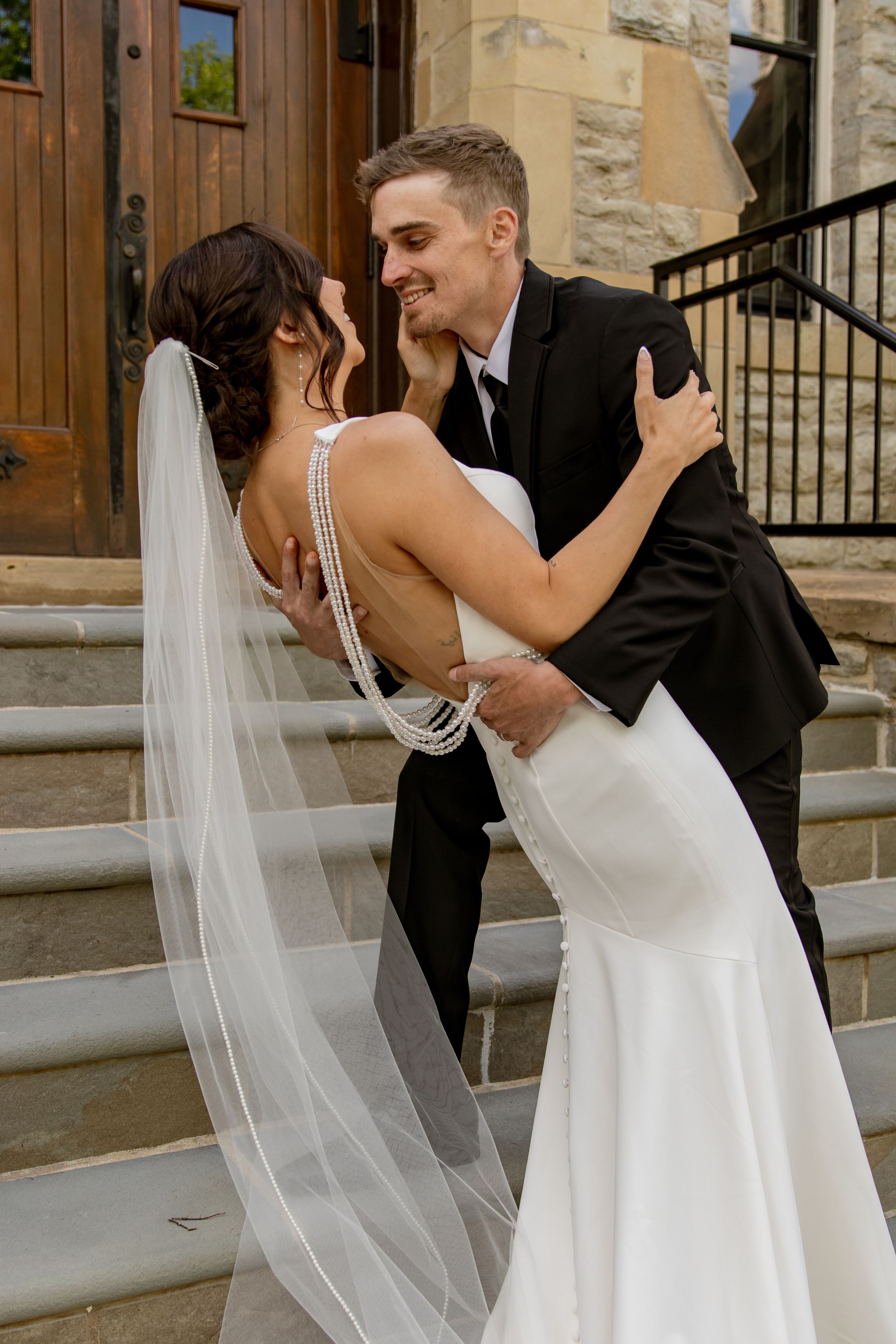 Happy wedding moment captured outside historic stone church steps.
