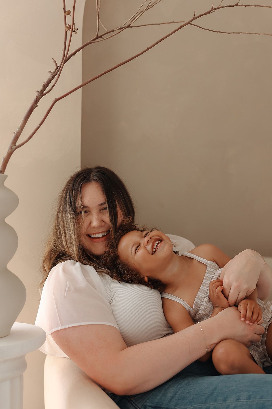 A candid moment of joyful laughter shared between two people relaxing together on a couch.