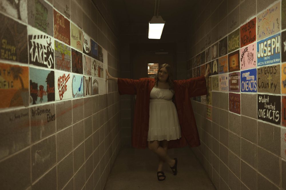 Long corridor with posters on walls and dramatic lighting creating tunnel effect.