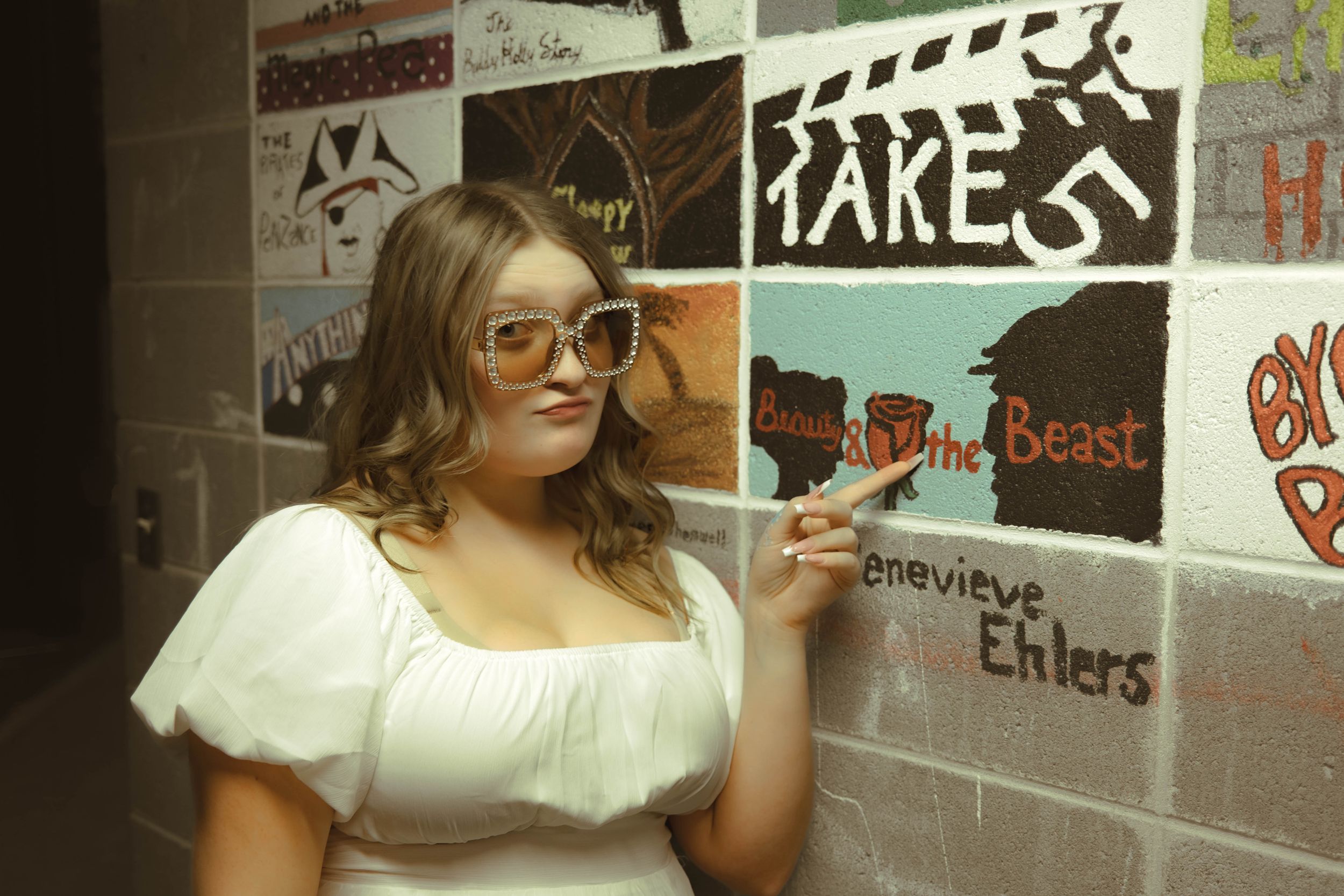 Theater hallway decorated with various show posters and artwork on the walls.