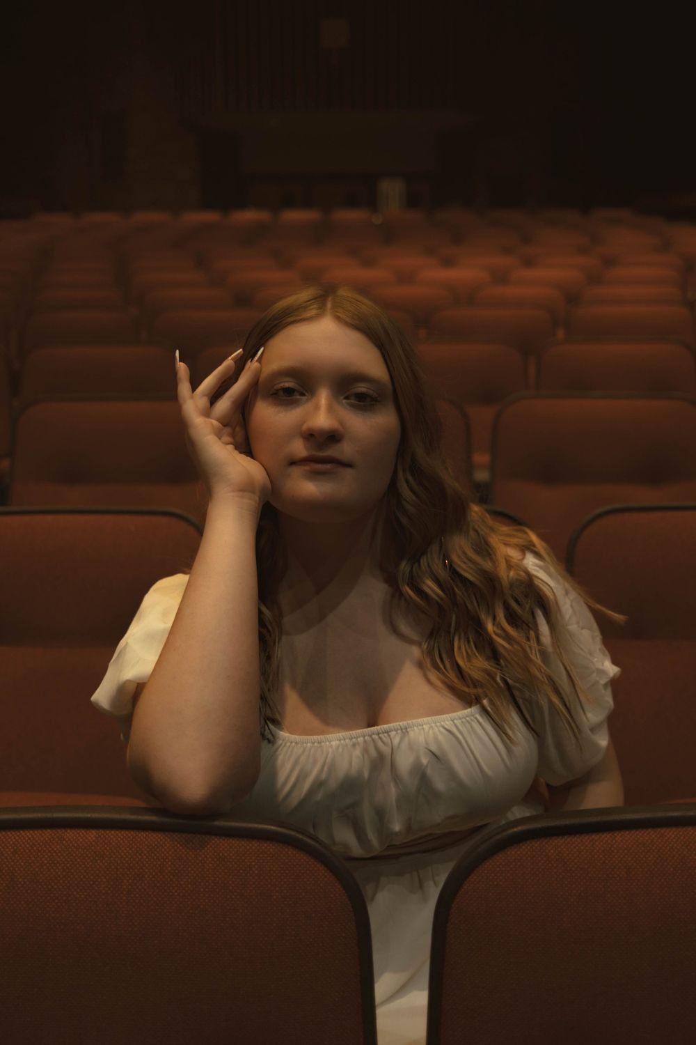 Dramatic theater scene with white costume and artistic lighting effects.