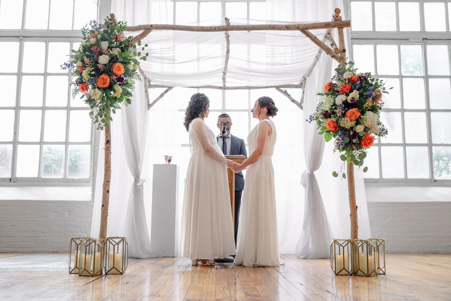 Evening wedding scene with string lights illuminating couple on grass.