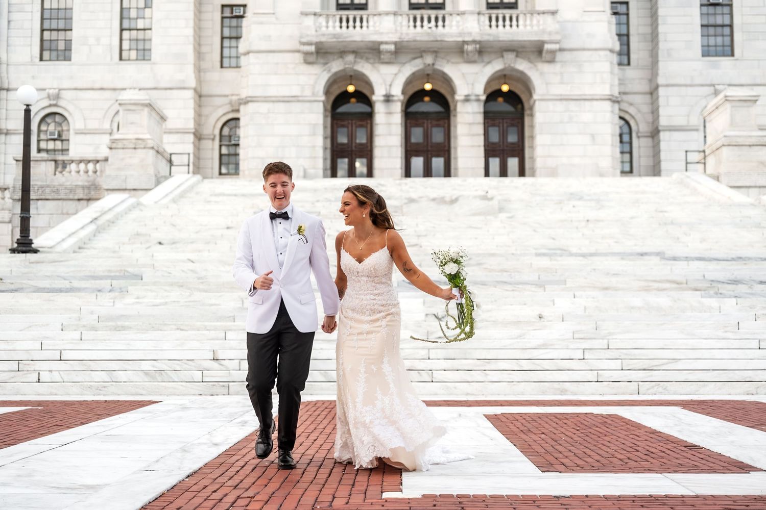 Evening wedding scene with string lights illuminating couple on grass.