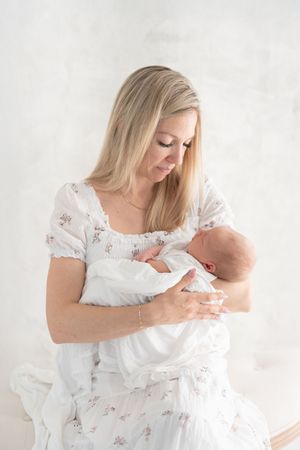 Nouvelle maman et son nouveau-né dans un décor haut de gamme lors de sa séance maternité au studio de photographie de Saint-Augustin-de-Desm