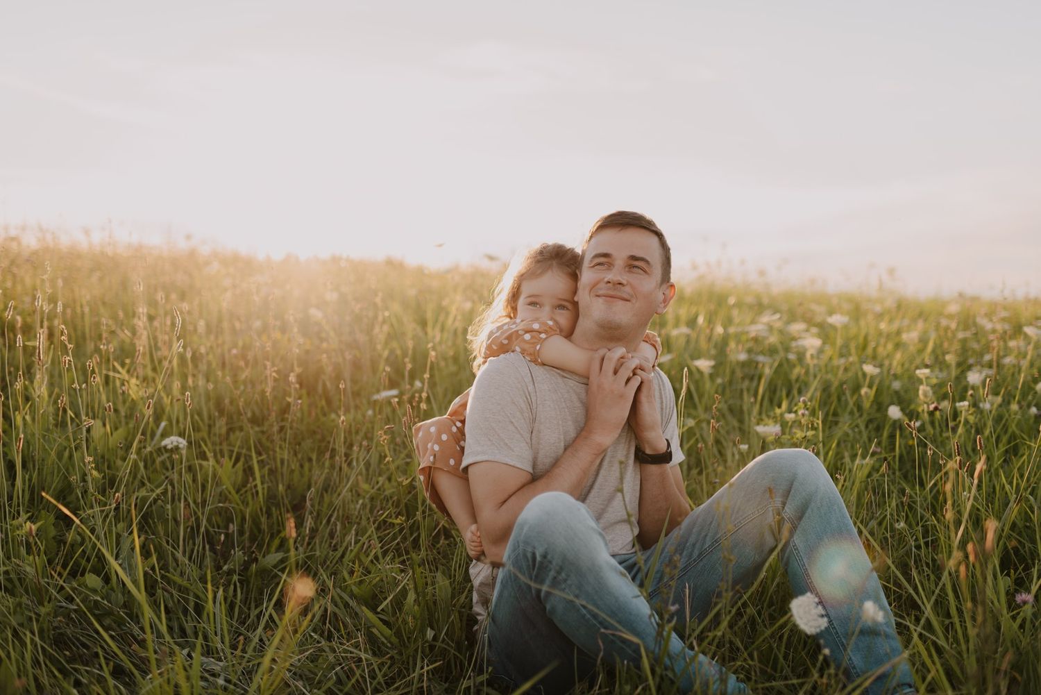 Sweet embrace shared in a sunlit meadow during golden hour.