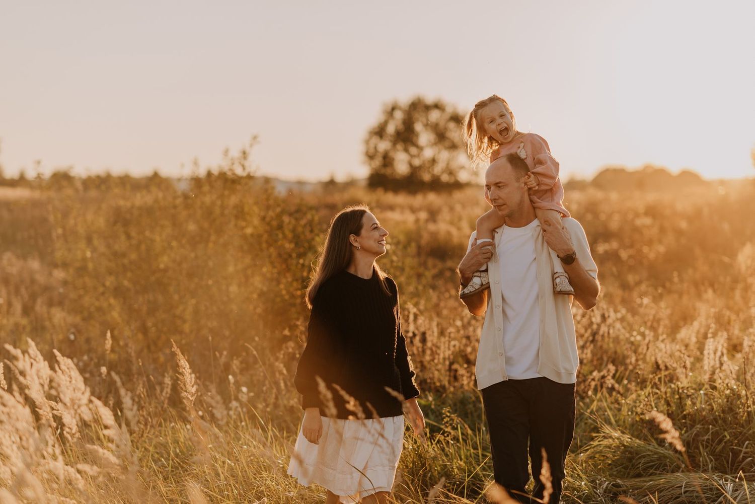 Candid moments captured during sunset in a rustic field with natural lighting.