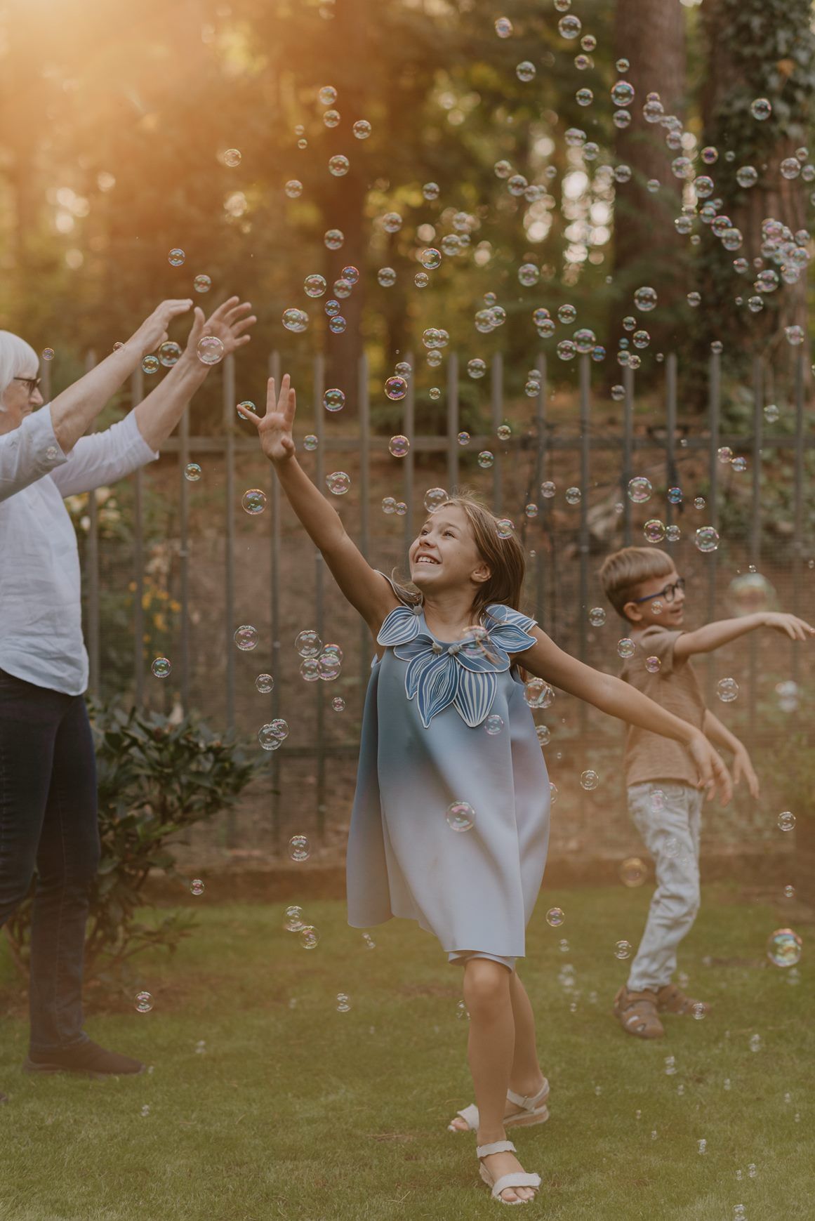 Playful scene with soap bubbles floating in a golden sunlit garden during sunset.