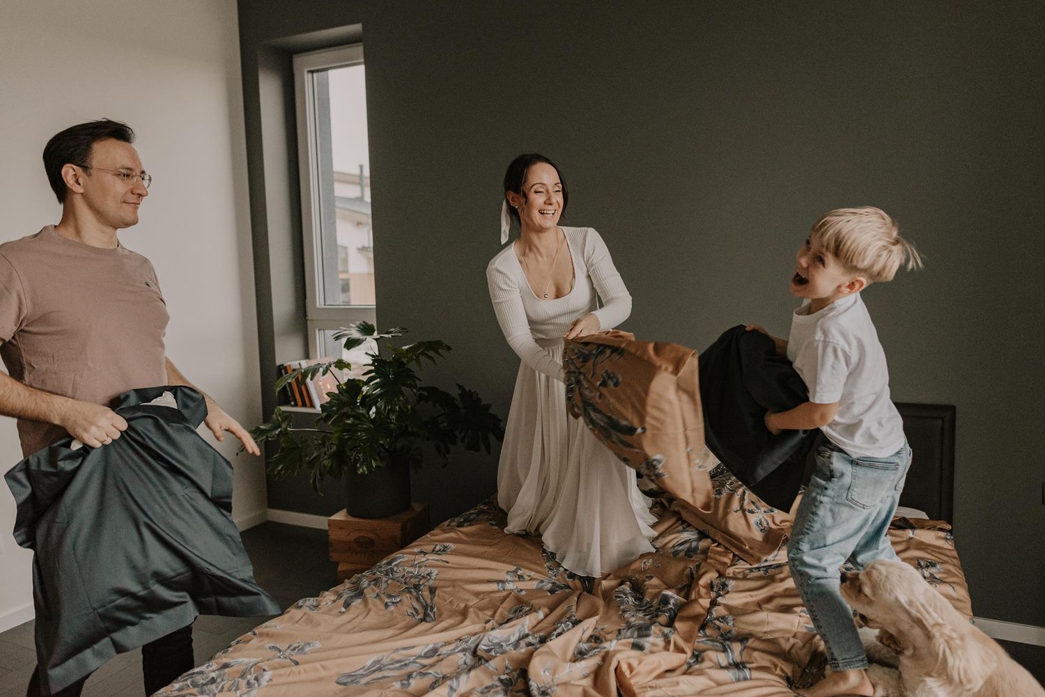 Playful family moment with everyone jumping on bed together.