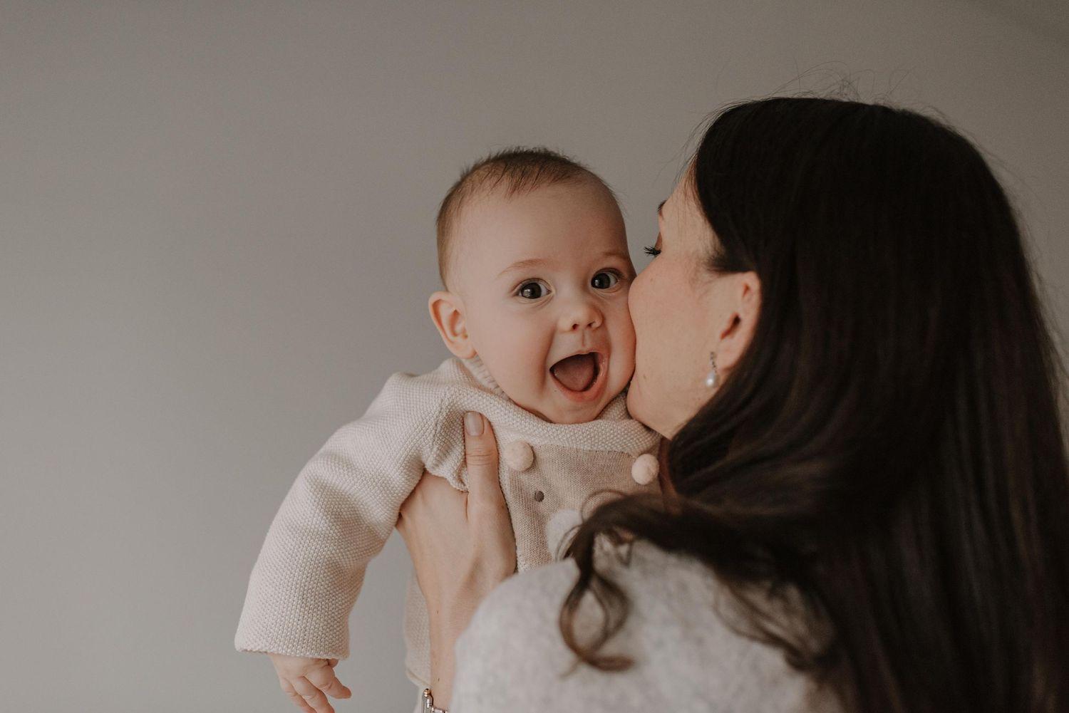 Candid family moment with laughing baby during mealtime.