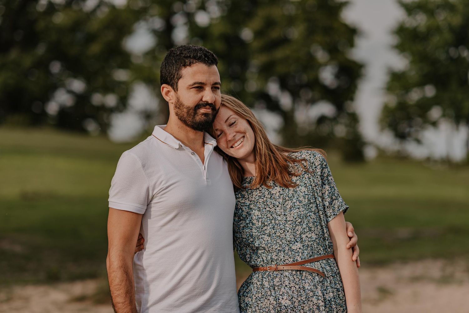 Intimate portrait of a couple embracing outdoors in warm evening light.